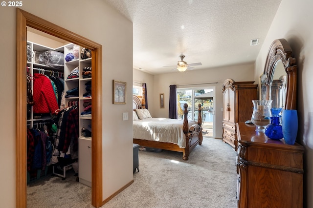 bedroom with access to exterior, visible vents, a spacious closet, and light colored carpet