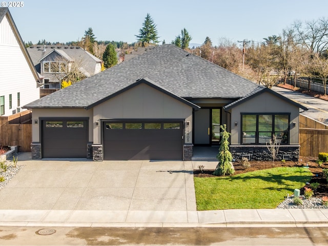 view of front of house with concrete driveway, a shingled roof, an attached garage, and stone siding