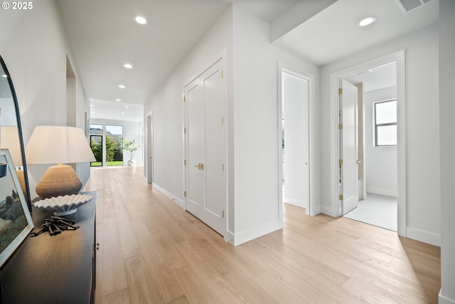 corridor with light wood-style floors, baseboards, and recessed lighting