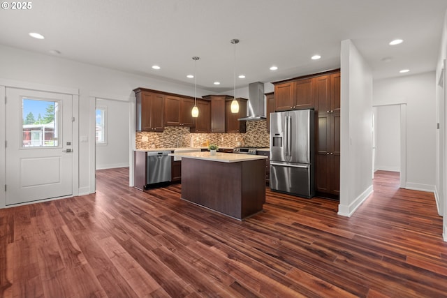 427 NW Garibaldi St, Hillsboro, OR 97124 - kitchen featuring appliances with stainless steel finishes, wall chimney range hood, light countertops, dark wood finished floors, and decorative backsplash