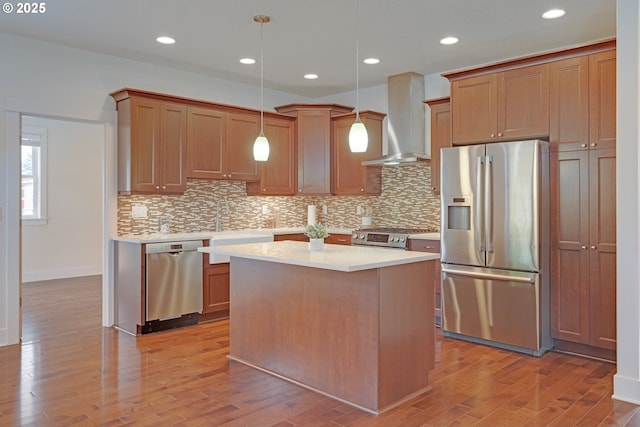 427 NW Garibaldi St, Hillsboro, OR 97124 - kitchen with stainless steel appliances, wall chimney exhaust hood, wood finished floors, light countertops, and a kitchen island