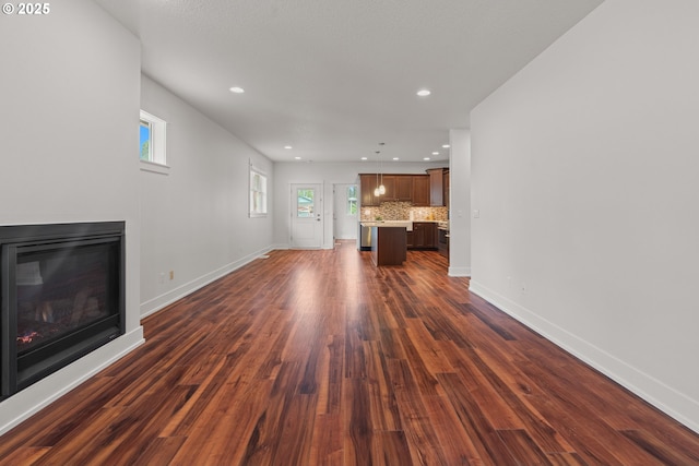 427 NW Garibaldi St, Hillsboro, OR 97124 - unfurnished living room with a glass covered fireplace, dark wood-style floors, baseboards, healthy amount of natural light, and recessed lighting