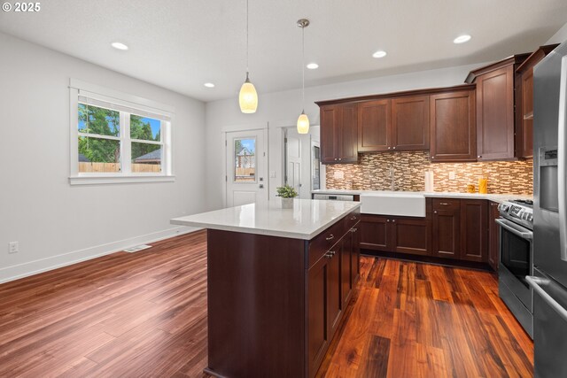 427 NW Garibaldi St, Hillsboro, OR 97124 - kitchen featuring a sink, dark wood-style floors, light countertops, appliances with stainless steel finishes, and backsplash