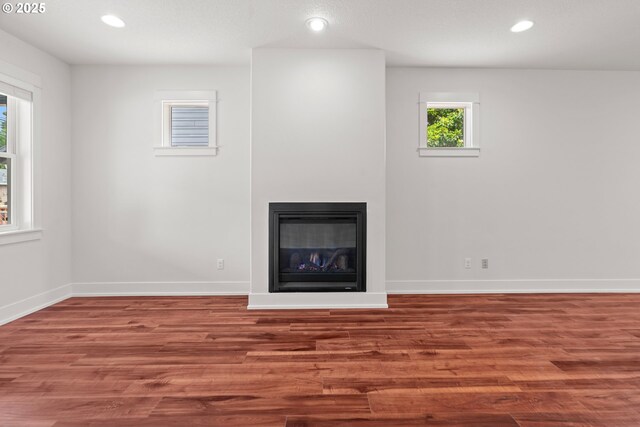 427 NW Garibaldi St, Hillsboro, OR 97124 - unfurnished living room featuring wood finished floors, recessed lighting, baseboards, and a glass covered fireplace