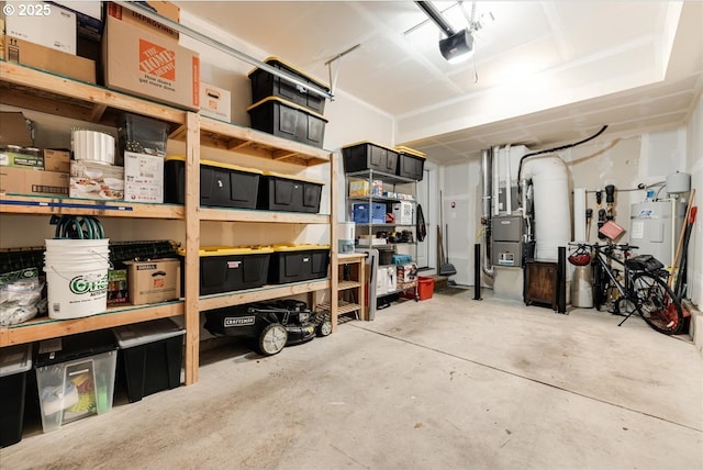 storage room with a garage, water heater, and heating unit