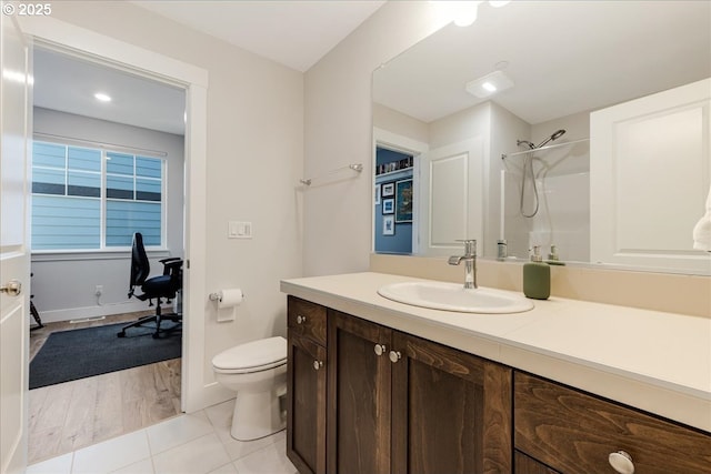 full bath with a shower, toilet, vanity, baseboards, and tile patterned floors