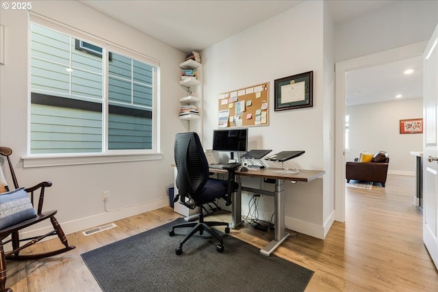 office featuring recessed lighting, light wood-type flooring, visible vents, and baseboards