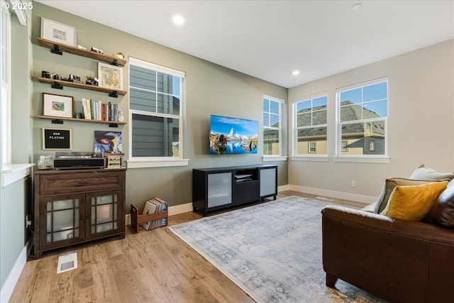 living area featuring recessed lighting, visible vents, baseboards, and wood finished floors