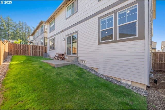 rear view of property with a yard, a patio area, a fenced backyard, and central air condition unit