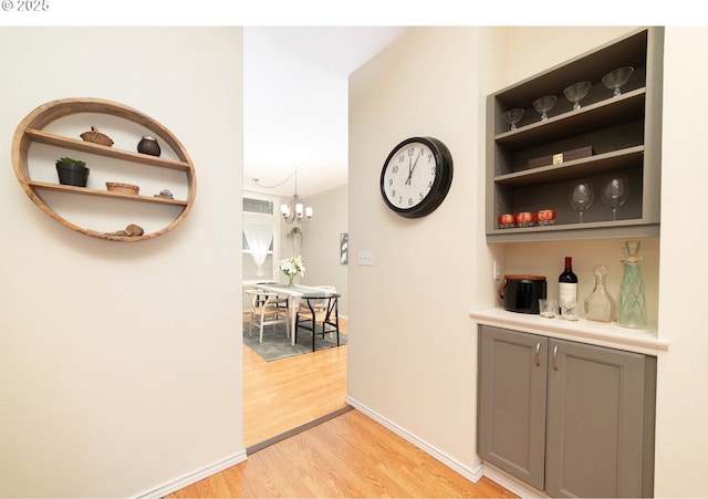 3540 S Corbett Ave, Portland, OR 97239 - bar area featuring light wood-style flooring, baseboards, and a chandelier