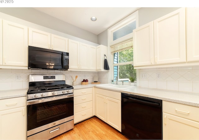 3540 S Corbett Ave, Portland, OR 97239 - kitchen featuring black appliances, backsplash, a sink, light wood-style floors, and recessed lighting