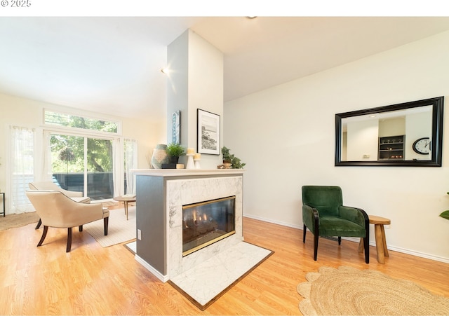 3540 S Corbett Ave, Portland, OR 97239 - living room with wood finished floors, a high end fireplace, baseboards, and lofted ceiling