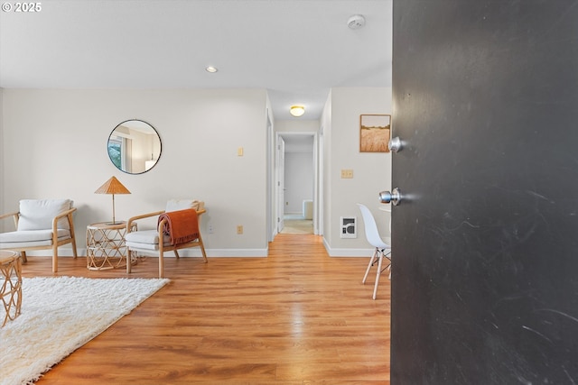 sitting room with light wood-type flooring, baseboards, and recessed lighting