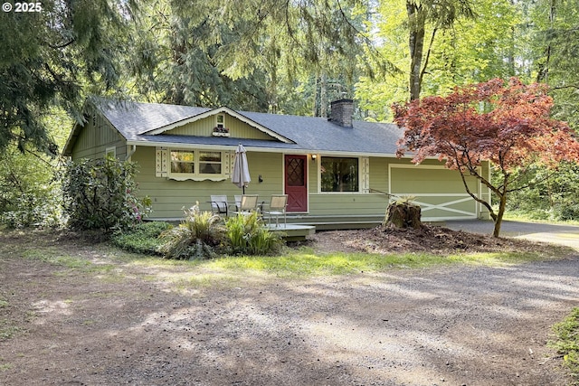 24782 E Welches Rd, Welches, OR 97067 - ranch-style house with driveway, a chimney, a garage, a shingled roof, and a porch