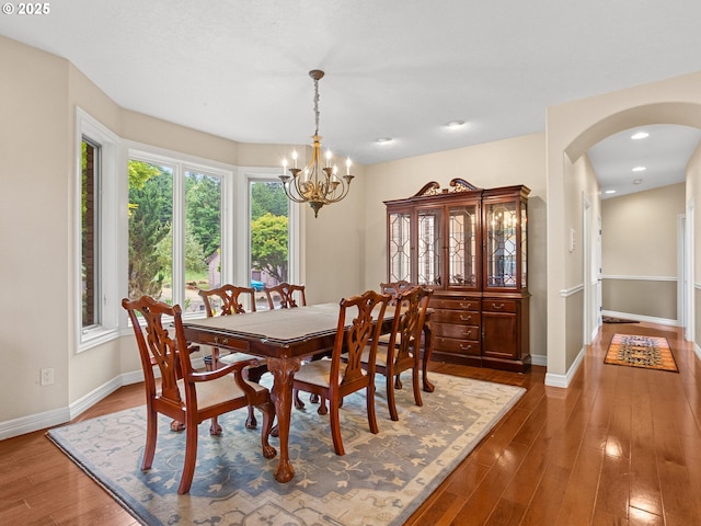 8801 SE Walnut Dr, Amity, OR 97101 - dining space with arched walkways, wood finished floors, a chandelier, baseboards, and recessed lighting