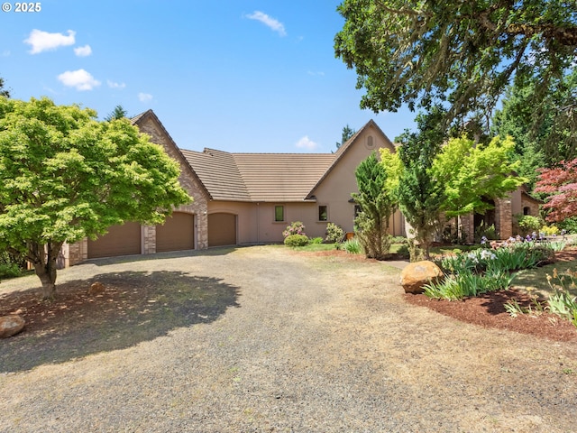 8801 SE Walnut Dr, Amity, OR 97101 - view of front of property featuring a garage, a tile roof, driveway, and stucco siding