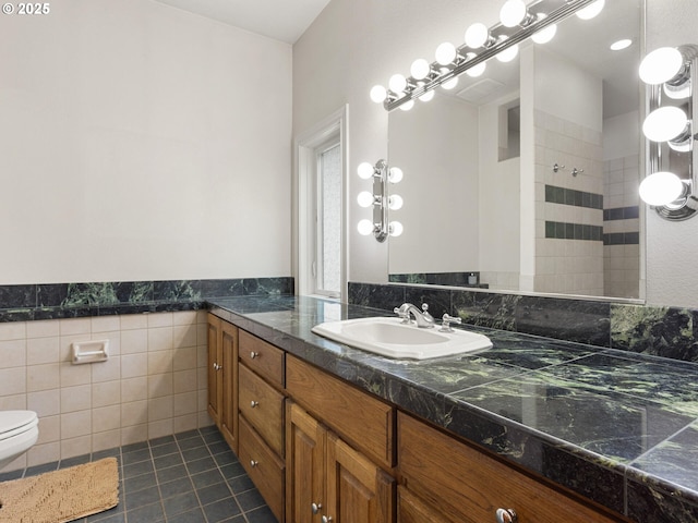 8801 SE Walnut Dr, Amity, OR 97101 - bathroom featuring vanity, tile patterned flooring, toilet, tiled shower, and tile walls