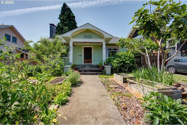 6115 SE 19th Ave, Portland, OR 97202 - bungalow-style home with a vegetable garden, a chimney, and covered porch