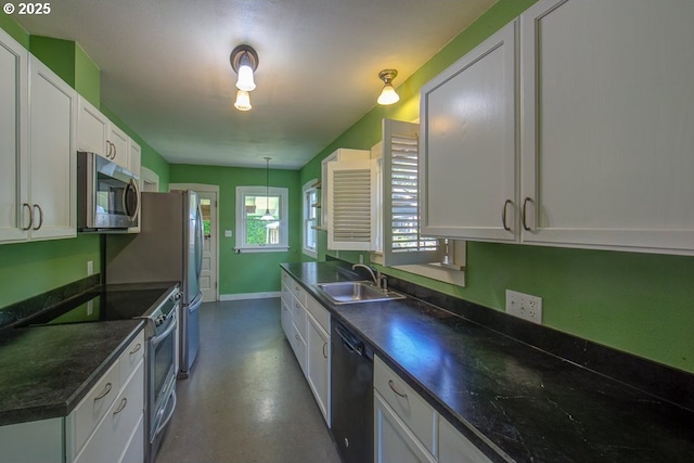 6115 SE 19th Ave, Portland, OR 97202 - kitchen with appliances with stainless steel finishes, dark countertops, white cabinetry, pendant lighting, and concrete flooring