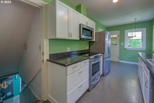 6115 SE 19th Ave, Portland, OR 97202 - kitchen with stainless steel appliances, white cabinets, dark countertops, pendant lighting, and finished concrete floors