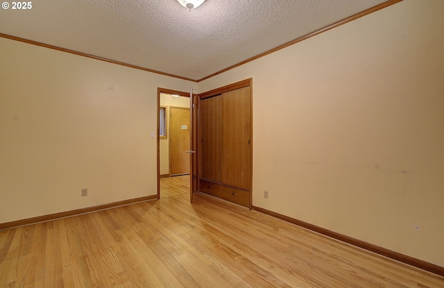 unfurnished room with baseboards, a textured ceiling, light wood-style flooring, and crown molding