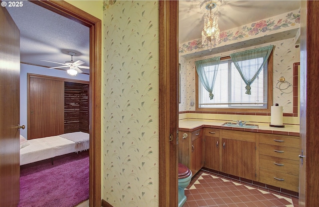 ensuite bathroom featuring toilet, connected bathroom, wallpapered walls, ceiling fan, and vanity