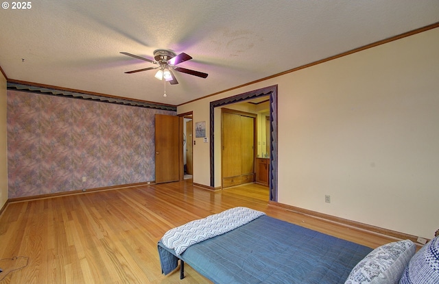 bedroom featuring crown molding, baseboards, light wood-style floors, a textured ceiling, and a ceiling fan