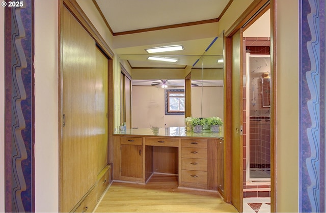 corridor with crown molding and light wood-style floors