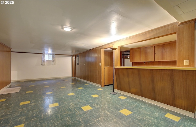 below grade area featuring wooden walls and baseboards