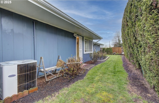 view of yard with central air condition unit and fence