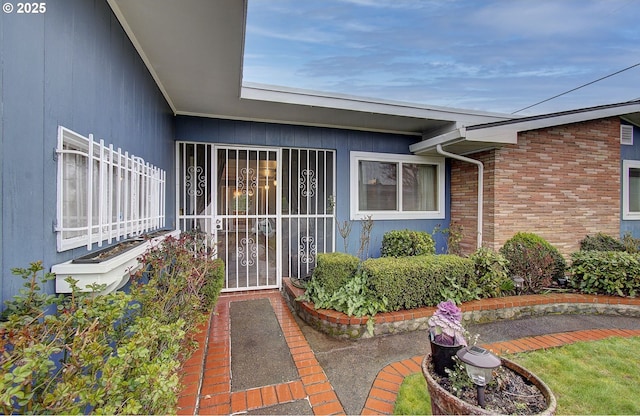 entrance to property with brick siding and fence