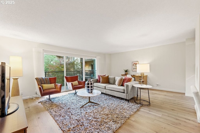 living room with a textured ceiling and light wood-type flooring