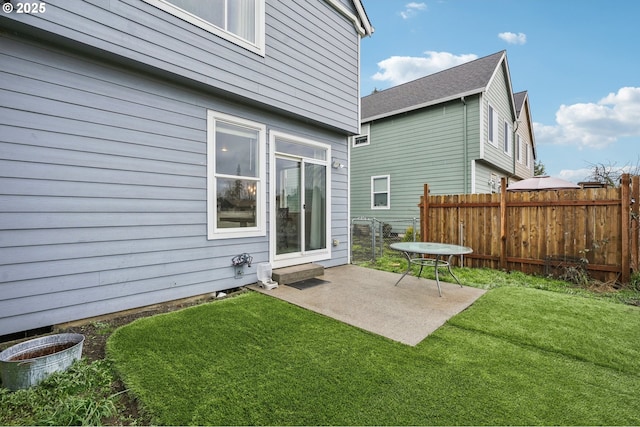 back of property featuring a yard, fence, and a patio