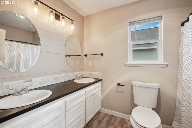 full bath featuring wood finished floors, tasteful backsplash, a sink, and toilet