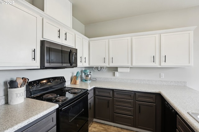 kitchen featuring a sink, electric range, white cabinets, and light countertops