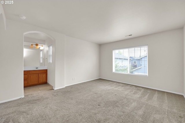 5298 Wales Dr, Eugene, OR 97402 - spare room featuring arched walkways, baseboards, light colored carpet, and visible vents