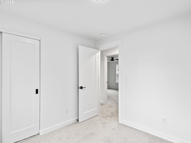 unfurnished bedroom featuring baseboards and light colored carpet