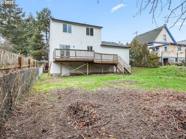 rear view of property featuring a fenced backyard, stairway, a lawn, and a wooden deck