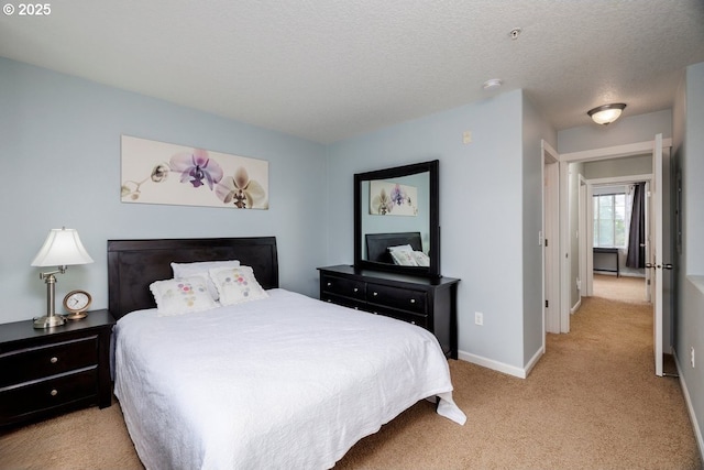 bedroom with light carpet, baseboards, and a textured ceiling