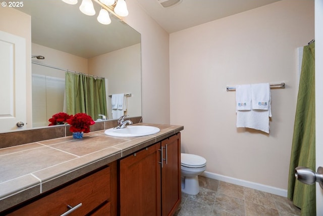 full bathroom featuring baseboards, toilet, vanity, and a shower with shower curtain
