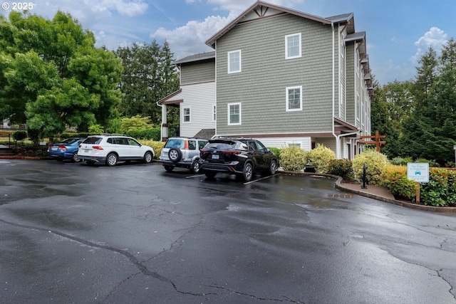 view of property exterior with uncovered parking