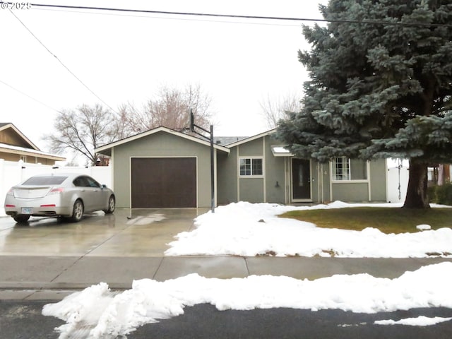 view of front of house featuring a garage, concrete driveway, and stucco siding