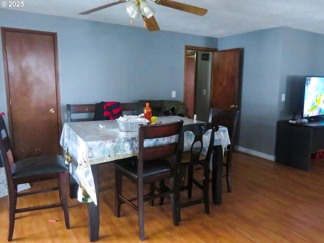 dining room with light wood-style flooring, baseboards, and ceiling fan