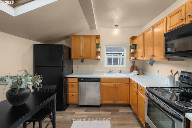 kitchen featuring sink, a skylight, black appliances, a textured ceiling, and dark hardwood / wood-style flooring