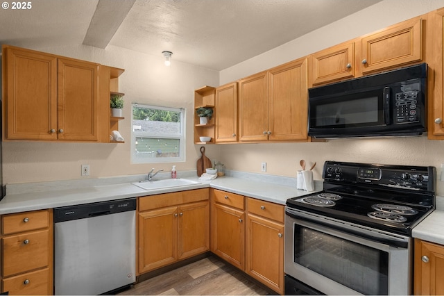 kitchen with appliances with stainless steel finishes, light hardwood / wood-style floors, and sink