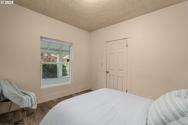 bedroom with dark wood-type flooring, a closet, and a textured ceiling