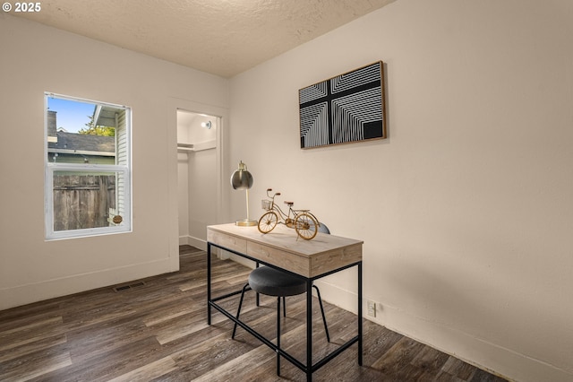 home office featuring dark wood-type flooring and a textured ceiling