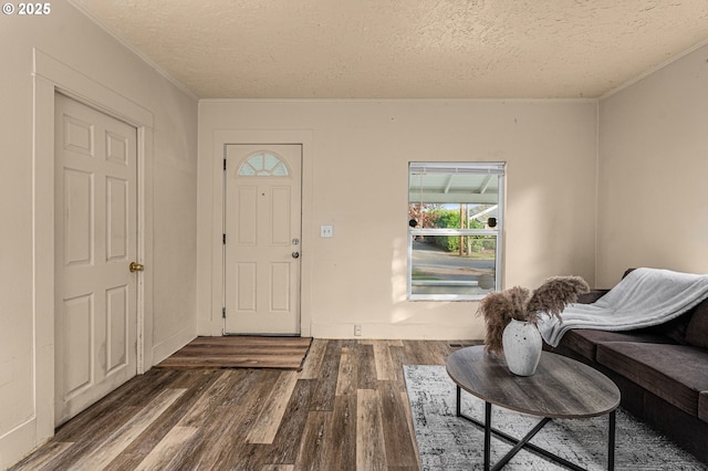 foyer entrance featuring dark hardwood / wood-style flooring, crown molding, and a textured ceiling