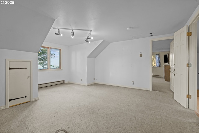 additional living space featuring light carpet, a baseboard heating unit, and lofted ceiling