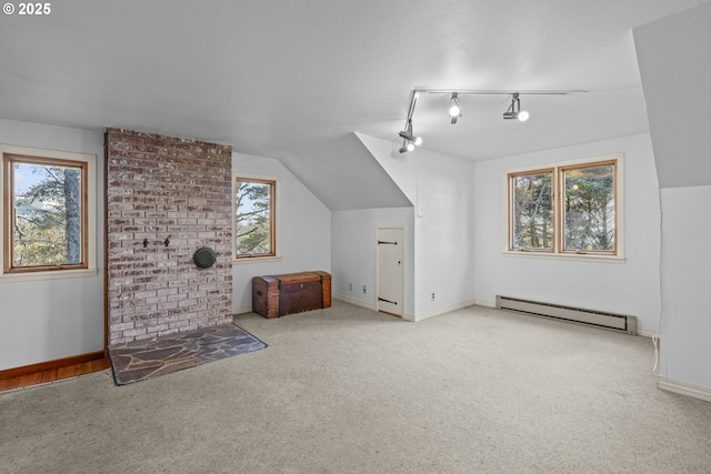 additional living space featuring lofted ceiling, plenty of natural light, carpet flooring, and baseboard heating